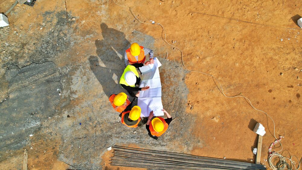 Aerial view of engineers reviewing plans on site